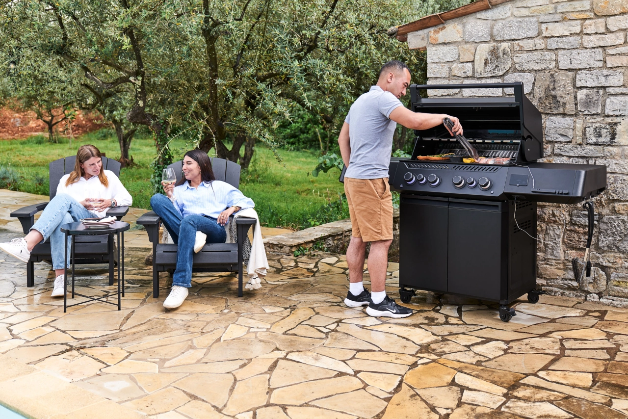 Grillgut auf dem Rost und Mann auf an dem Grill