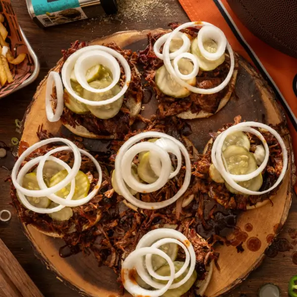 Fingerfood für die Super Bowl Party - Pulled Pork Burger auf einem Holzklotz