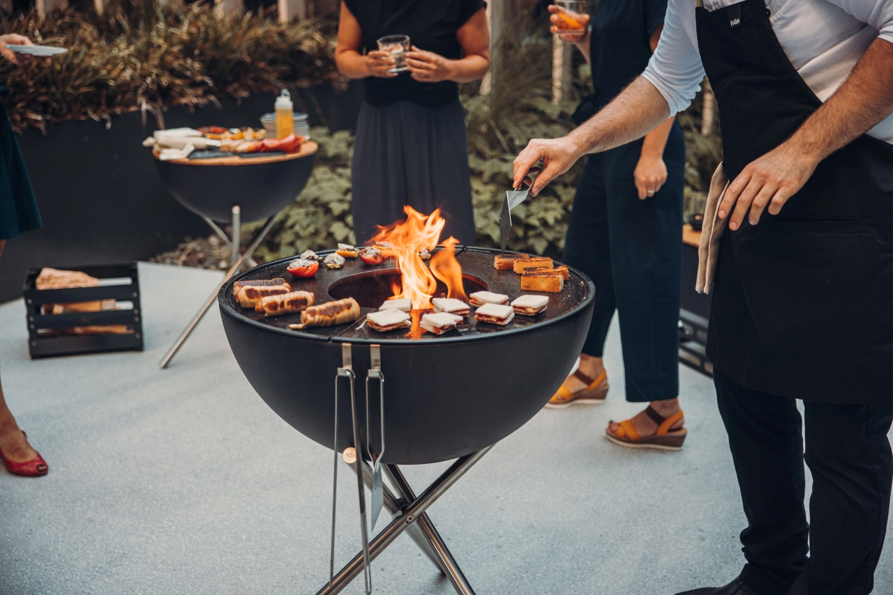 Mann und Frau am Grill mit Fleisch