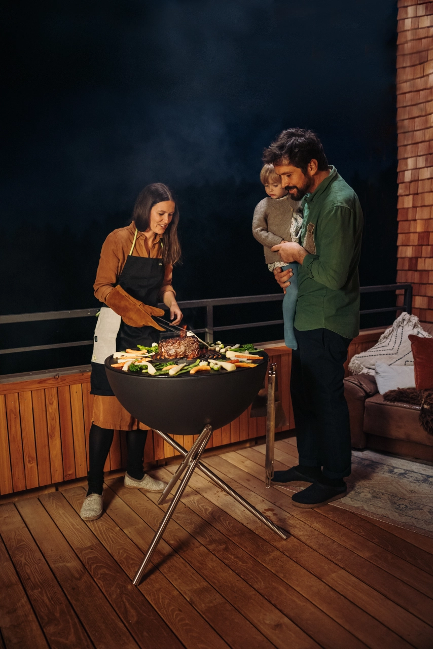 Mann und Frau am Grill mit Fleisch