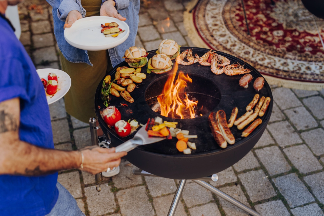 Mann am Grill mit Fleisch