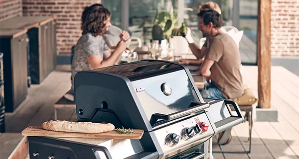 Enders Enders Gasgrill im Vordergrund mit einer Party im Hintergrund