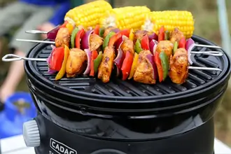 Verschiedene Cadac Camping Zubehörteile wie Grillplatten, Töpfe und Taschen für Outdoor-Abenteuer.