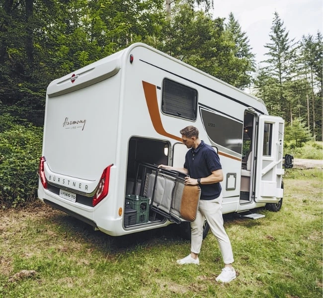 Wohnmobil, Campingstühle, Wald, Heckgarage eines Wohnmobils