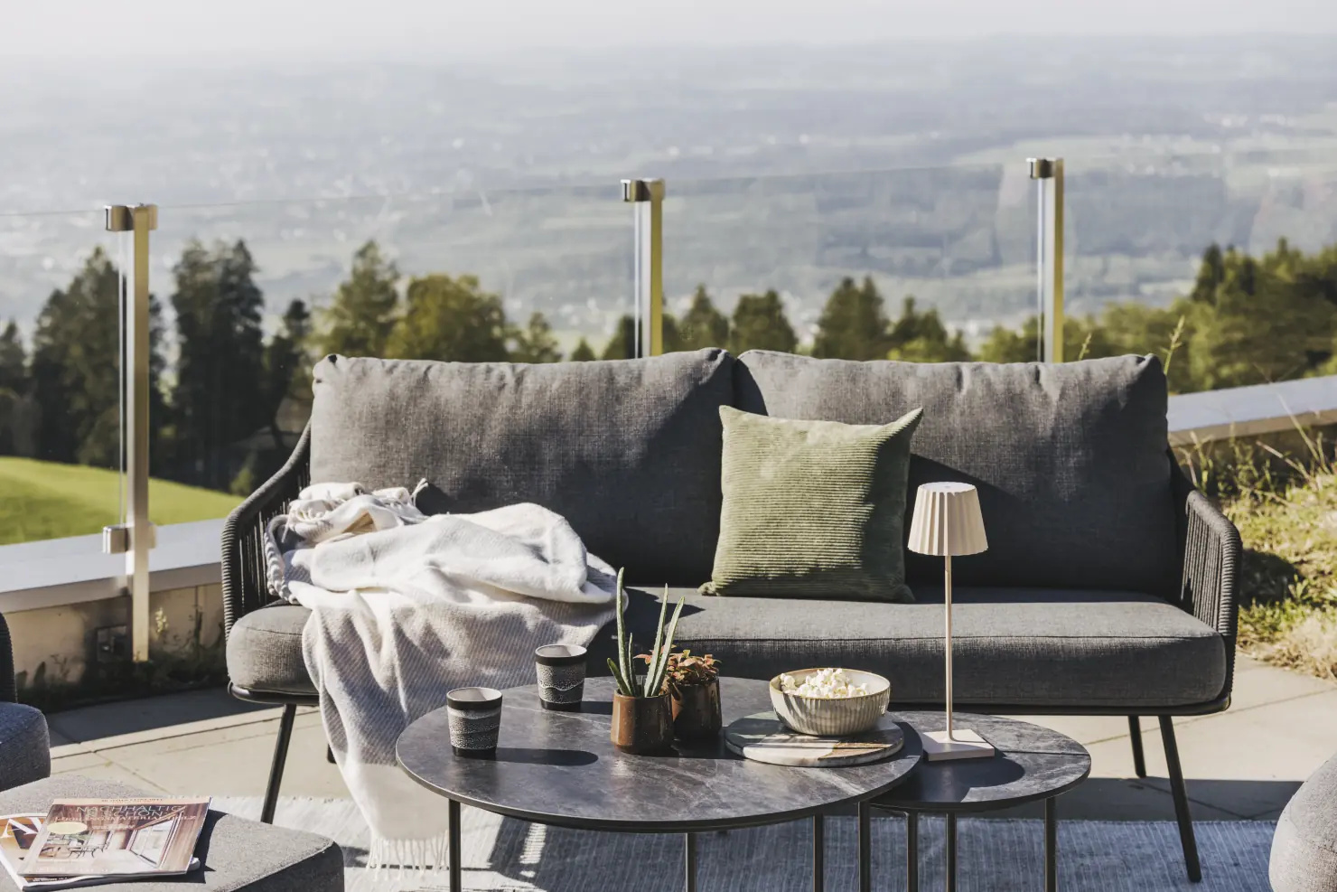 Produktfoto mit Auflagen und eine Gruppe auf einer Terrasse mit Meerblick