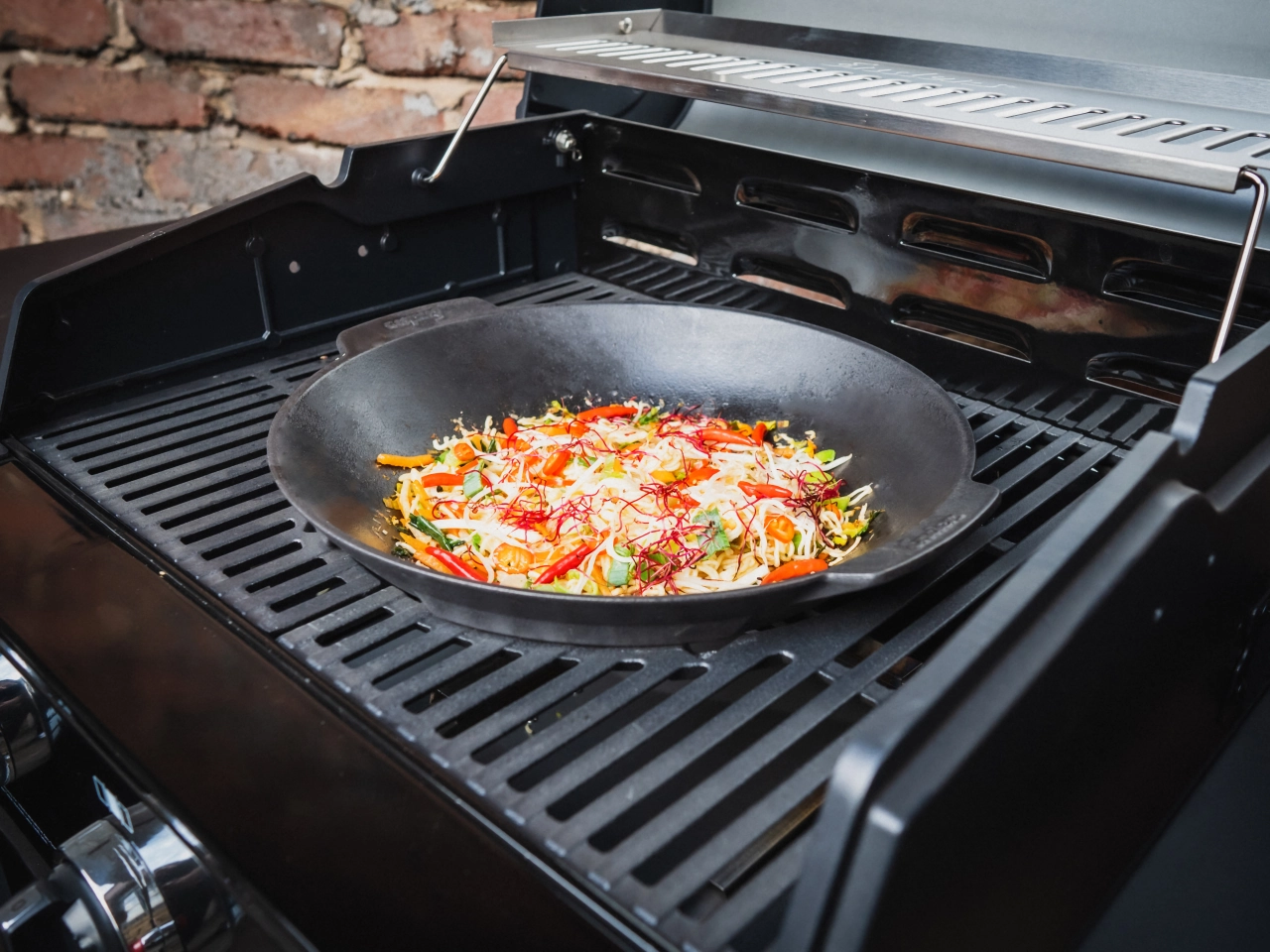 Wok mit Essen im Grill eingelegt