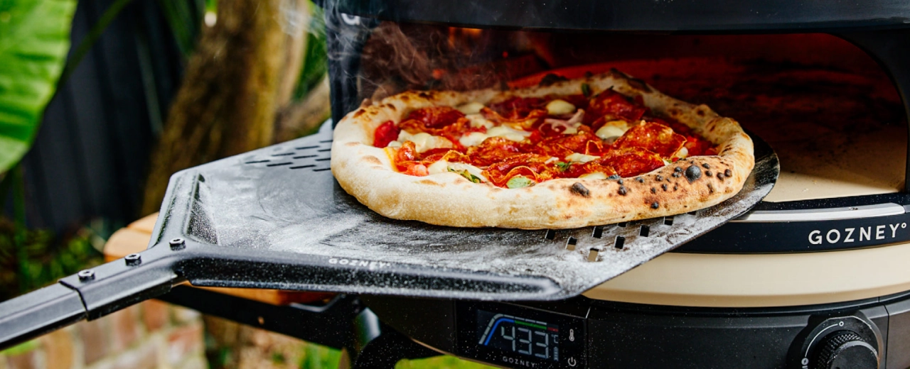 Pizza wir auf dem Schieber in den Dome geschoben