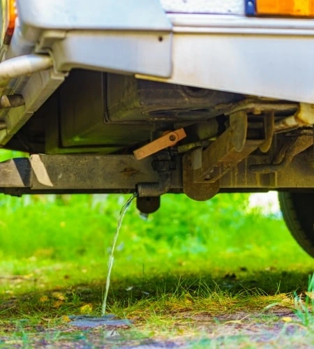 Wasser fließt aus Rohr unter einem Wohnwagen