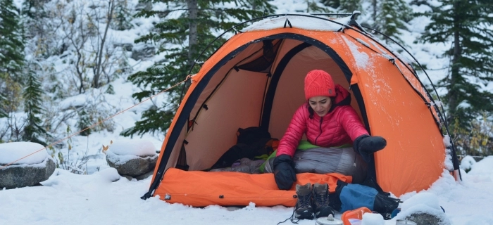 Schnee Landschaft mir einer Frau im Roten Outfit in einem Orangefarbenen Zelt