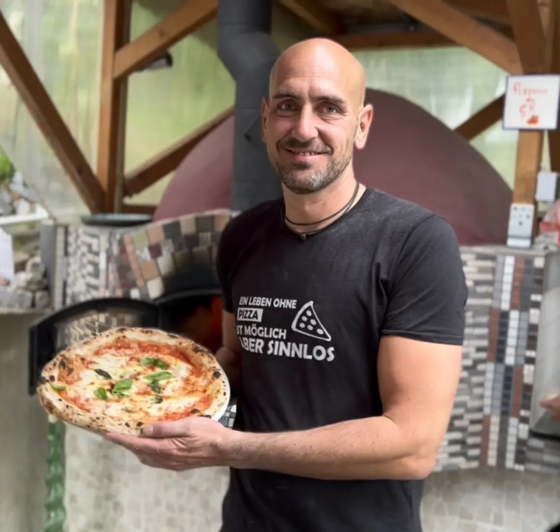 Marco Esposito hält napoletanische Pizza hoch