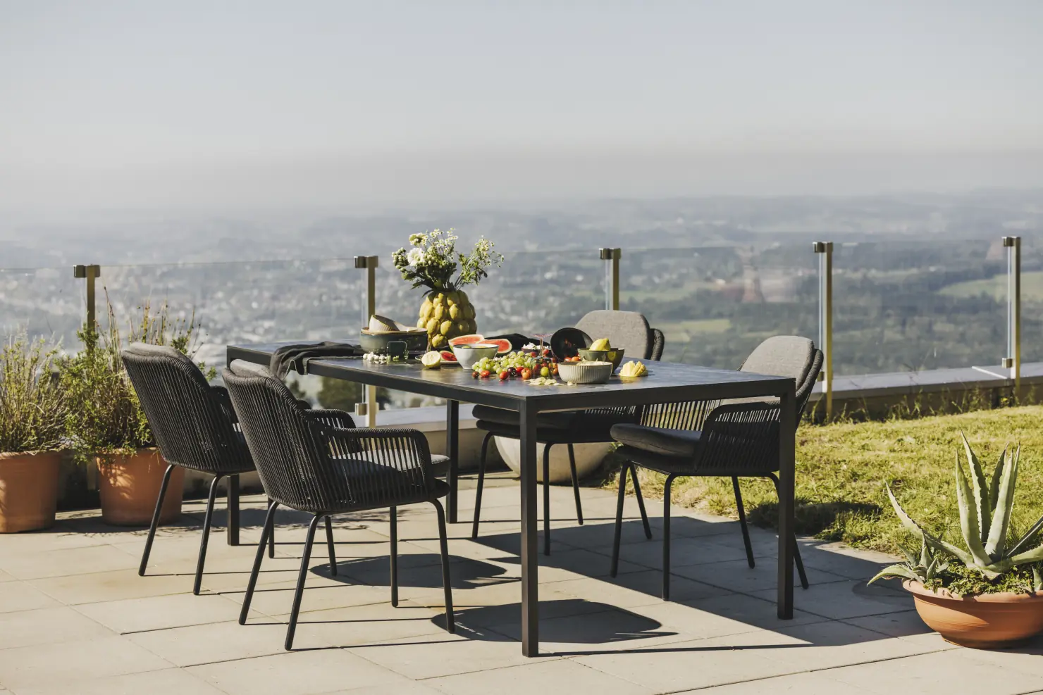 Produktfoto mit Auflagen und eine Gruppe auf einer Terrasse mit Meerblick