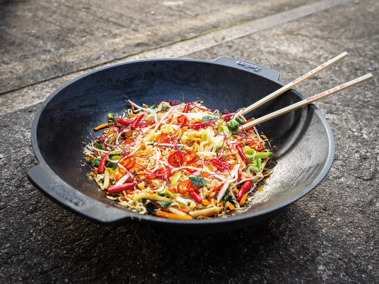 Wok mit Essen im Grill eingelegt