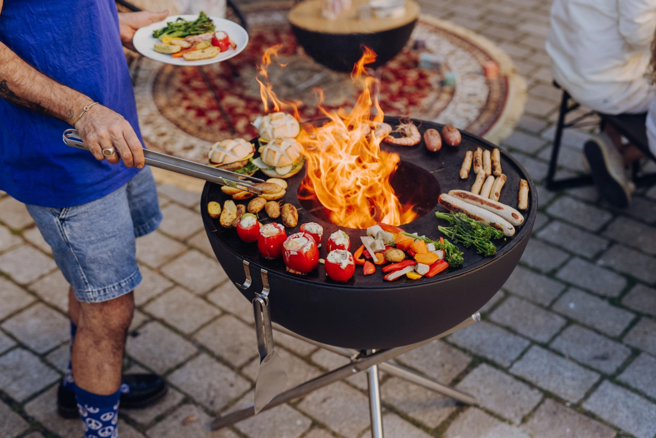 Mann am Grill mit Fleisch